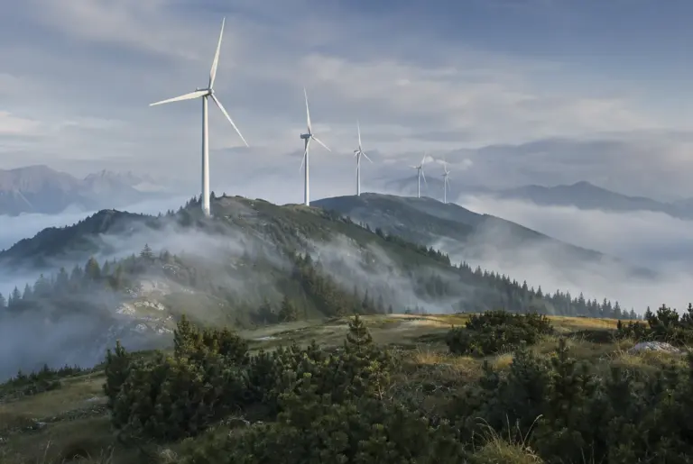 Windkraftanlagen auf einem nebelverhangenen Bergrücken in den steirischen Alpen